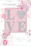 This romantic anniversary card is a gentle celebration of enduring love, blending soft pastel pinks, silvery greys, and pearly whites to create an atmosphere of treasured intimacy, much like a quiet evening at home in Thornton Heath after a bouquet delivery arrives. At its centre, the word "LOVE" is elegantly spelled out in soft, raised glitter, with each letter outlined in a delicate shimmer that catches the light without feeling overpowering. The letter "O" is transformed into a gleaming, textured silver heart, symbolising the bond between two people and adding a focal point that naturally draws the eye. Surrounding this central word, delicate blossoms in blush, mauve, and pale ivory unfurl with a gentle, almost watercolour softness. Their fine, flowing lines and light shading give the sense of petals just opening on a cool spring morning, like flowers in a small Thornton Heath garden after rain. Interlaced among the blooms are slender vines, curls, and filigree flourishes, along with tiny decorative butterflies and floating petals that suggest movement and a touch of whimsy. These details mimic the graceful curves and layering a florist might use when arranging an anniversary bouquet for delivery around Parchmore Road or nearby residential streets. The text "On Our Anniversary" and the tender sentiment "I love you today and always" appear in understated, elegant script, harmonising with the soft design rather than competing with it. Overall, this card feels like a quiet, heartfelt keepsake-paper and glitter standing in for roses and gypsophila-created to accompany an anniversary celebration and the shared memories it honours in Thornton Heath.